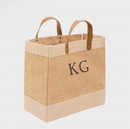 Beige tote bag with 'KG' monogram on a light gray background